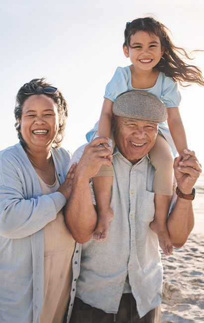 grandparents at the beach with their granddaughter wealth management.jpg